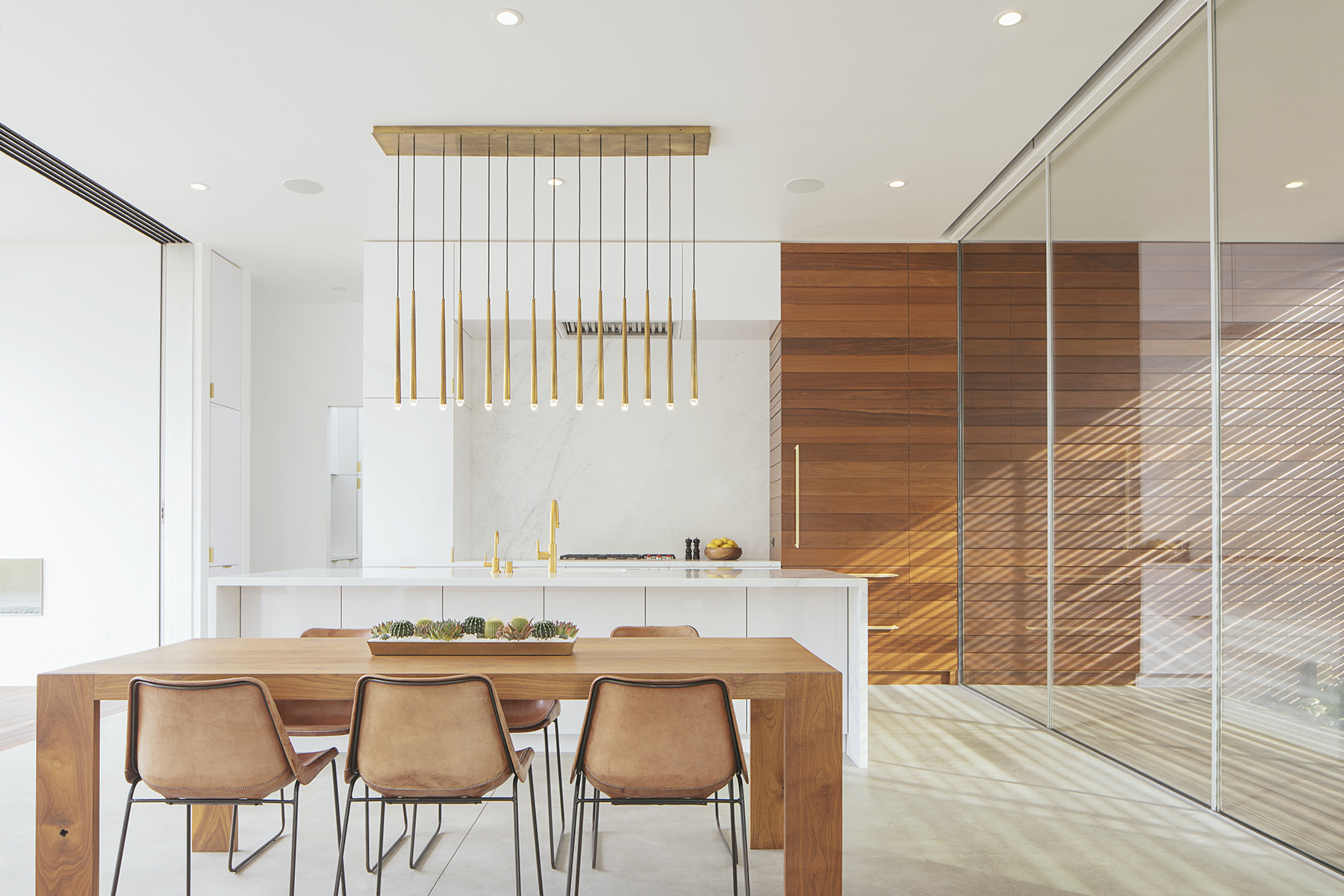A bright, minimal designed kitchen, with a dining table and chairs.